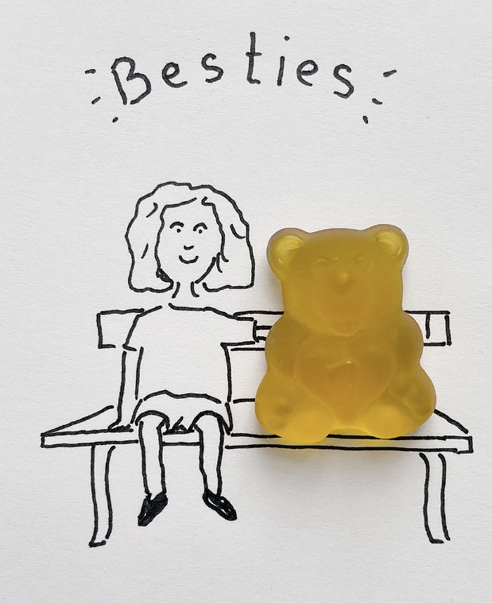 Gezeichnetes Mädchen sitzt neben einem Fruchtsaftbären auf einer Bank, darüber steht Besties