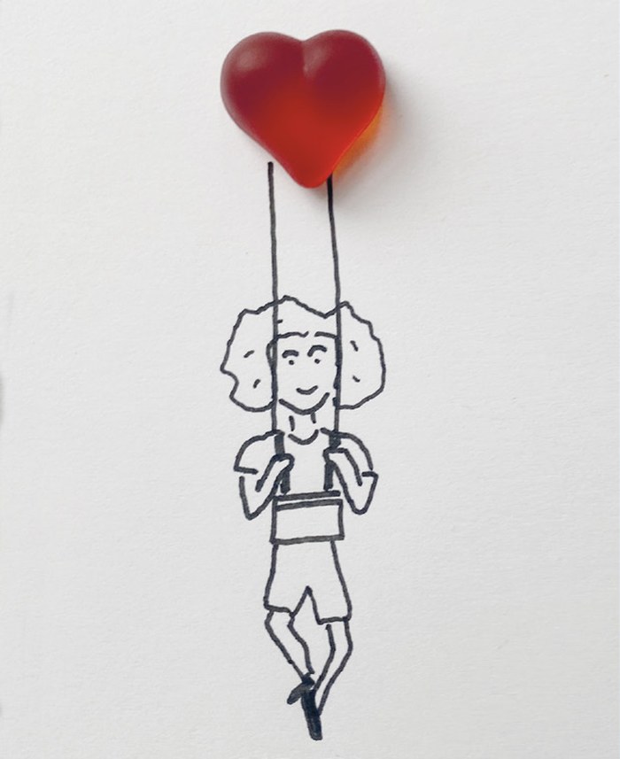 Gezeichnete Figur hängt an einem roten Fruchtgummi-Herz und schwebt nach oben