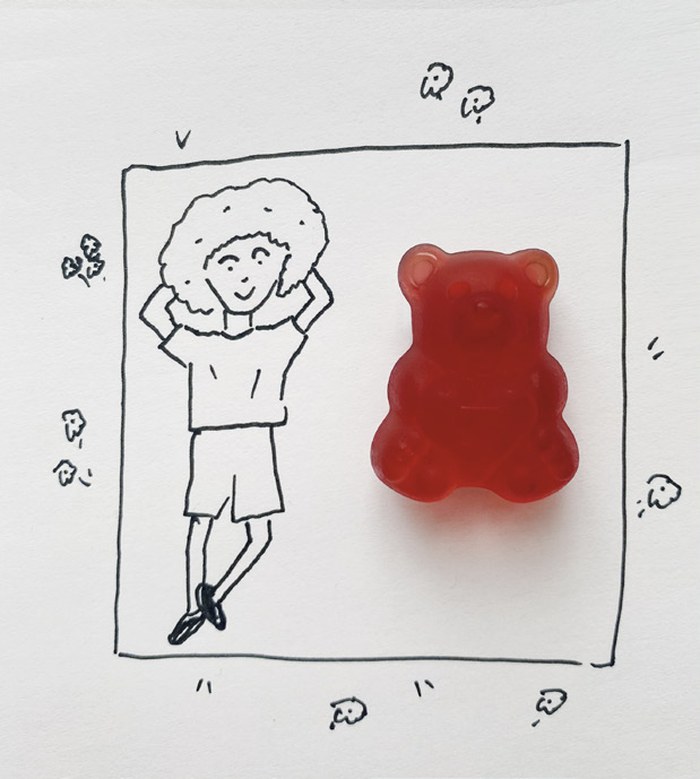 Gezeichnete Figur liegt entspannt mit den Händen hinter dem Kopf neben einem Fruchtsaftbären