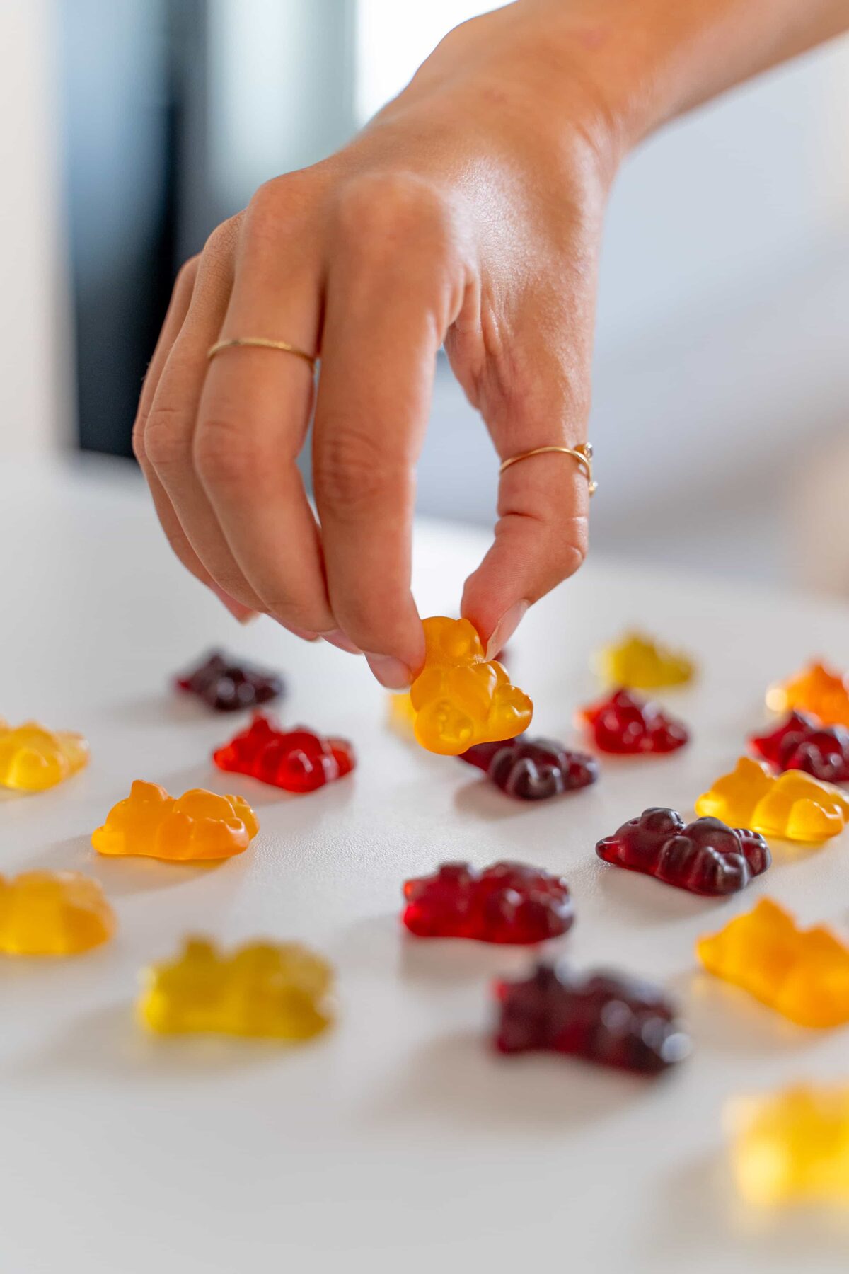 Hand nimmt einen NATURFEH Fruchtsaftbären von einem hellen Tisch