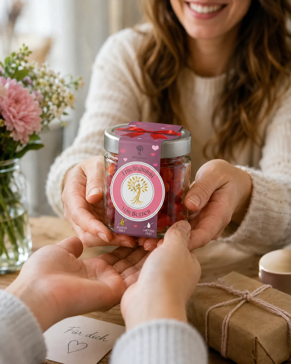NATURFEH Geschenkglas Von Herzen wird über einen Tisch gereicht
